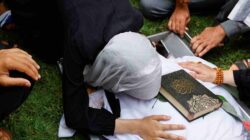 Soliuman Abu Anza, yang terbunuh dalam serangan Israel, berduka atas jenazahnya dengan salinan Al-Quran di atasnya